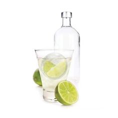 two limes and a bottle of water on a white background