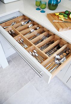 an open drawer in a kitchen filled with utensils