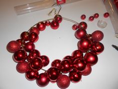 a bunch of red ornaments sitting on top of a white table next to pens and markers