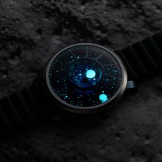 a watch with glowing blue numbers on it's face sitting in the dark sand