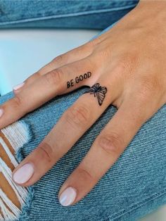 a woman's hand with a bee tattoo on her left thumb and the words be good written in black ink