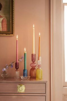 a dresser with candles and vases on it