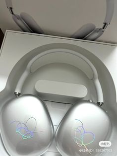 two silver headphones sitting in a box