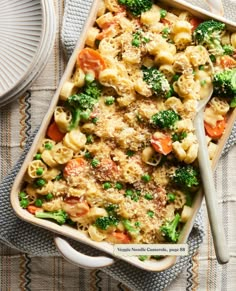 a casserole dish with broccoli, carrots and noodles in it