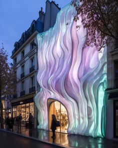 a building that looks like it is made out of wavy material and has people walking by