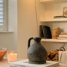 a vase sitting on top of a book next to a candle