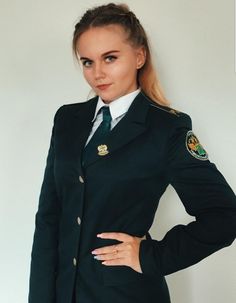 a woman in uniform is posing for the camera with her hands on her hips and one hand on her hip