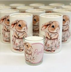 a group of candles that are sitting next to each other in front of some bunny mugs