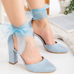 a woman wearing blue high heels with a bow on the ankle