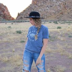 girl in blue jeans with a blue t-shirt wearing on open crown black felt hat