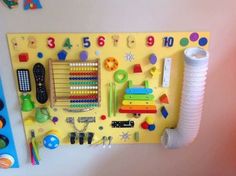 a yellow peg board with lots of different items on it and toys hanging from the wall