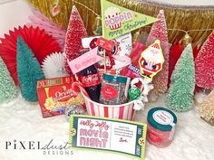 a christmas gift basket with candy, candies and other holiday treats in front of trees