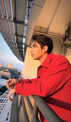 a man standing on top of a balcony next to a building