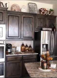 a kitchen with dark wood cabinets and stainless steel appliance on the counter top