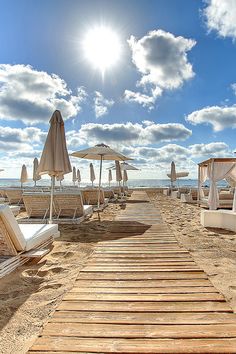 there are many umbrellas and chairs on the beach