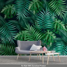 a living room with a couch and table in front of a large wall mural that has green leaves on it