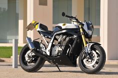 a black and silver motorcycle parked in front of a building