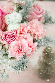 a bouquet of pink and white flowers sitting on top of a table