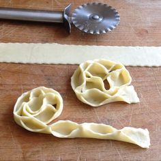 two uncooked ravioli sitting on top of a cutting board next to a knife