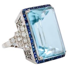 Impressive Emerald Cut Aquamarine surrounded by French Cut Sapphires and Diamond Ring Eleanor is named for Former First Lady Eleanor Rosevelt, who received a stunning 1,298 Carat Aquamarine from President Vargas of Brazil in 1936. What a gift! Brazil continues to produce the finest quality Aquamarines just as you will find in our "Eleanor." An unbelievable piece from another era assured to make you feel like an iconic movie star! This exquisite ring boasts a 45.41 Carat Emerald Step Cut Aquamari Emerald Cut Aquamarine Ring, Jewerly Ring, Estate Jewelry Rings, First Ladies, Platinum Diamond Rings, Gold Cocktail Ring, Aquamarine Jewelry, Discount Jewelry, Aquamarine Rings