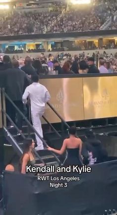 the man is walking down the stairs in front of an audience at a sporting event