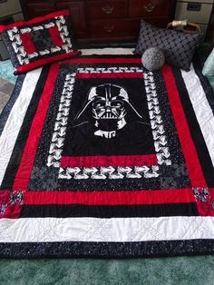 a bed with a star wars quilt on top of it next to pillows and a pillow