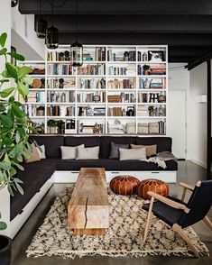 a living room filled with furniture and bookshelves next to a large book shelf