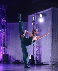 a woman is doing a handstand on stage