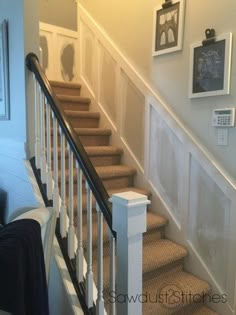 there is a stair case on the wall next to the carpeted stairs in this house