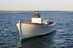 a man sitting on the bow of a small boat