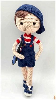 a crocheted doll is wearing overalls and holding a wrench in her hand