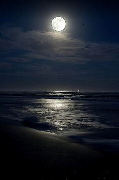 the full moon shines brightly in the night sky over the water at the beach