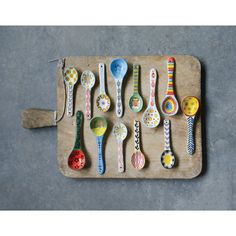 spoons are lined up on a tray with different designs and colors, including ladybugs