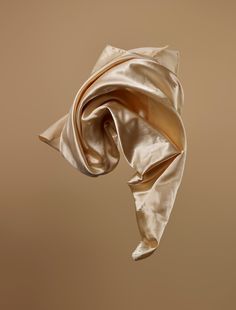 an image of a silk scarf blowing in the wind on a brown background with room for text