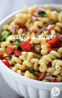 pasta salad in a white bowl with the words really good pasta salad on it's side