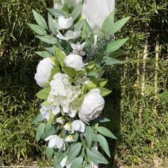 a vase filled with white flowers and greenery