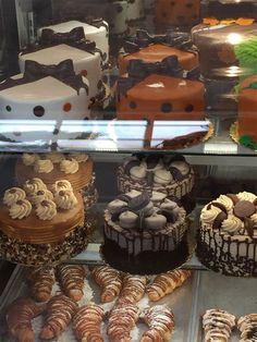 a display case filled with lots of different types of cakes and pastries next to each other