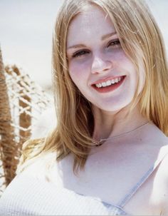 a woman with blonde hair smiling at the camera