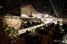 a room with tables, chairs and flowers in vases