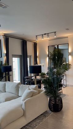 a living room filled with white furniture and lots of windows