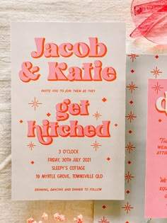 the wedding stationery is pink and white with red lettering on it, along with some candy