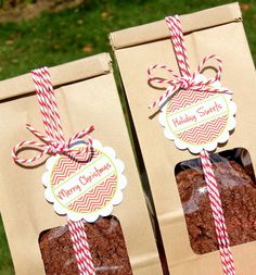 two brownies are wrapped in paper and tied with red and white striped twine