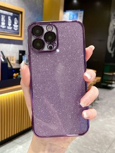 a woman holding up her purple phone case in front of the camera with two buttons on it