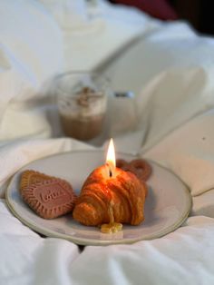 a plate with cookies and a lit candle on it in the shape of a heart