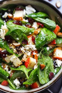 spinach salad with cranberries, nuts and feta cheese in a bowl