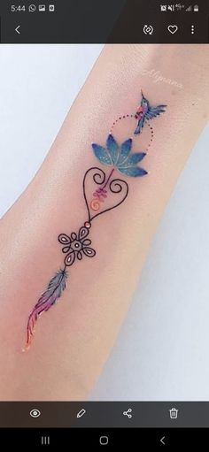 a small tattoo on the arm of a woman with blue flowers and two hummings