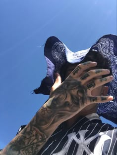 a man with tattoos on his arm holding up a cell phone