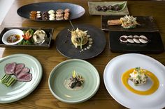 a table topped with plates filled with different types of food and garnishes