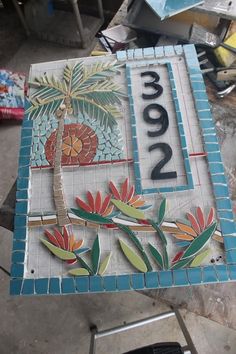 a mosaic tile sign with a palm tree on it