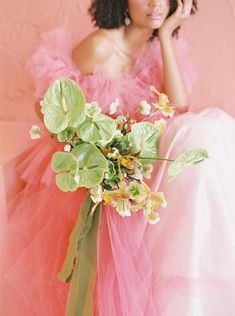 a woman in a pink dress holding a flower bouquet